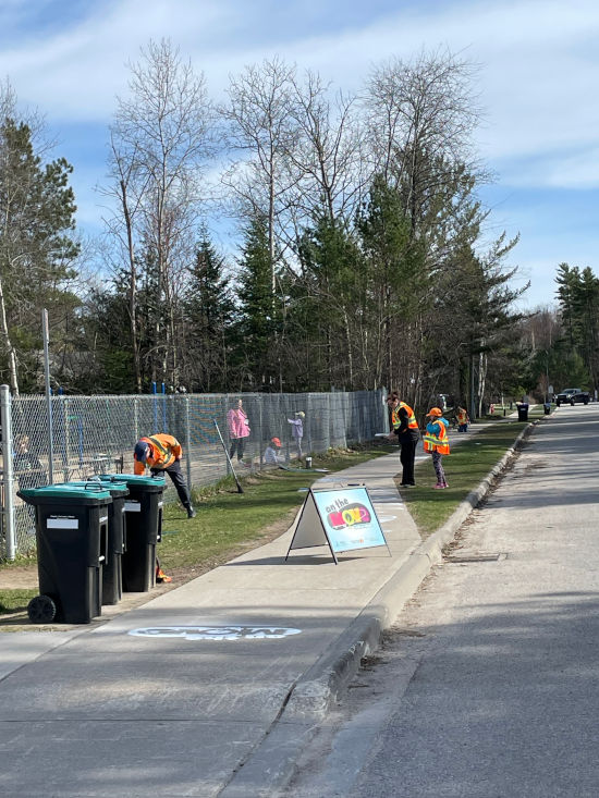street view image of participants working on sidewalk painting using the On the Move stencils