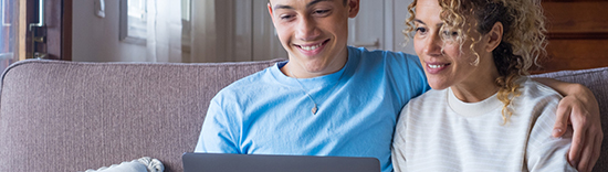 mom and son on couch together looking at laptop