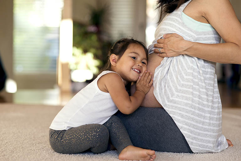 Mom pregnant with young daughter beside her